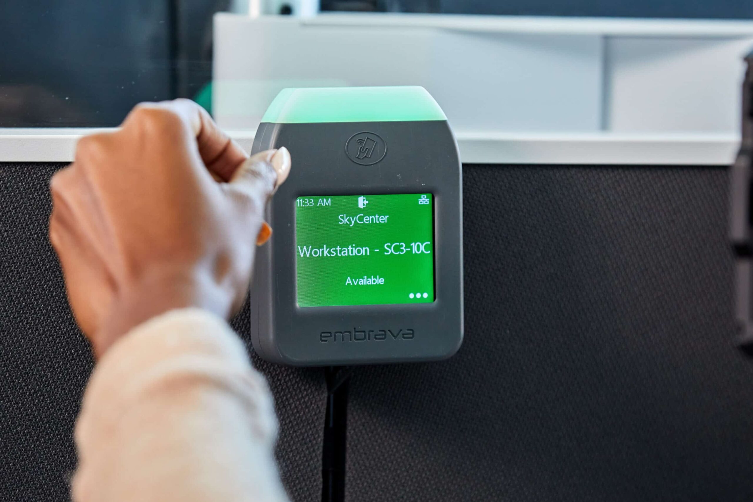 A person uses a gray touchscreen device; SkyCenter Workstation SC3-10C Available with green light showing availability.